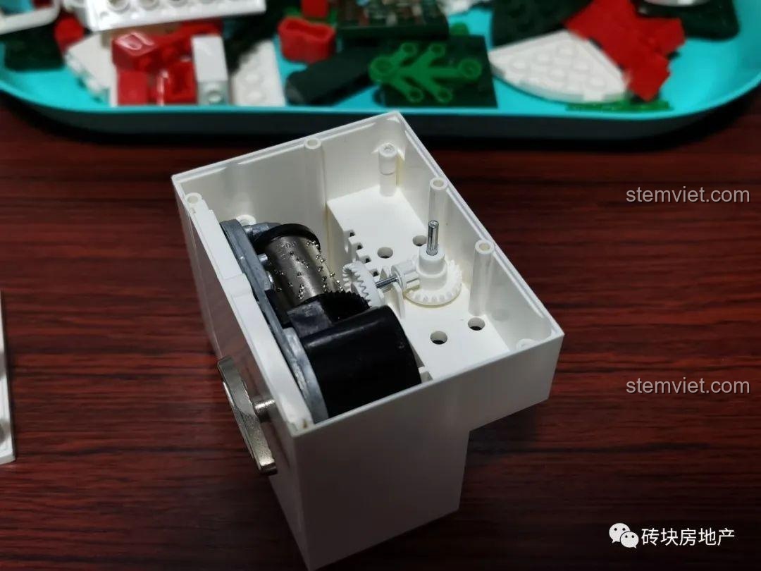 Bộ phận hộp nhạc đã được lắp đặt vào phần đế của mô hình Hộp nhạc Giáng Sinh Zhe Gao QL0981, sẵn sàng cho các bước tiếp theo.