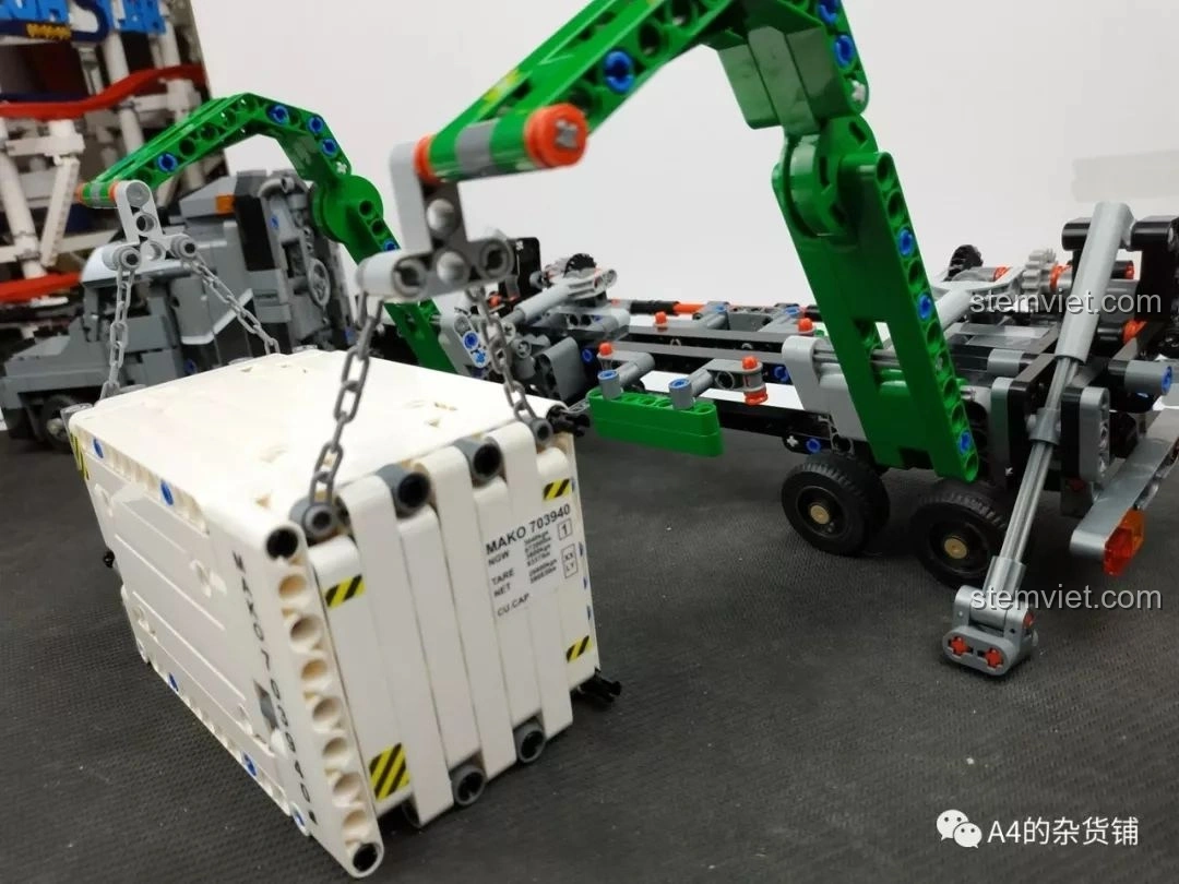 Cần cẩu của xe tải đang nâng container màu trắng, thể hiện chức năng cơ khí của bộ lắp ráp Xe Tải Container Cơ Khí SEMBO 703940.