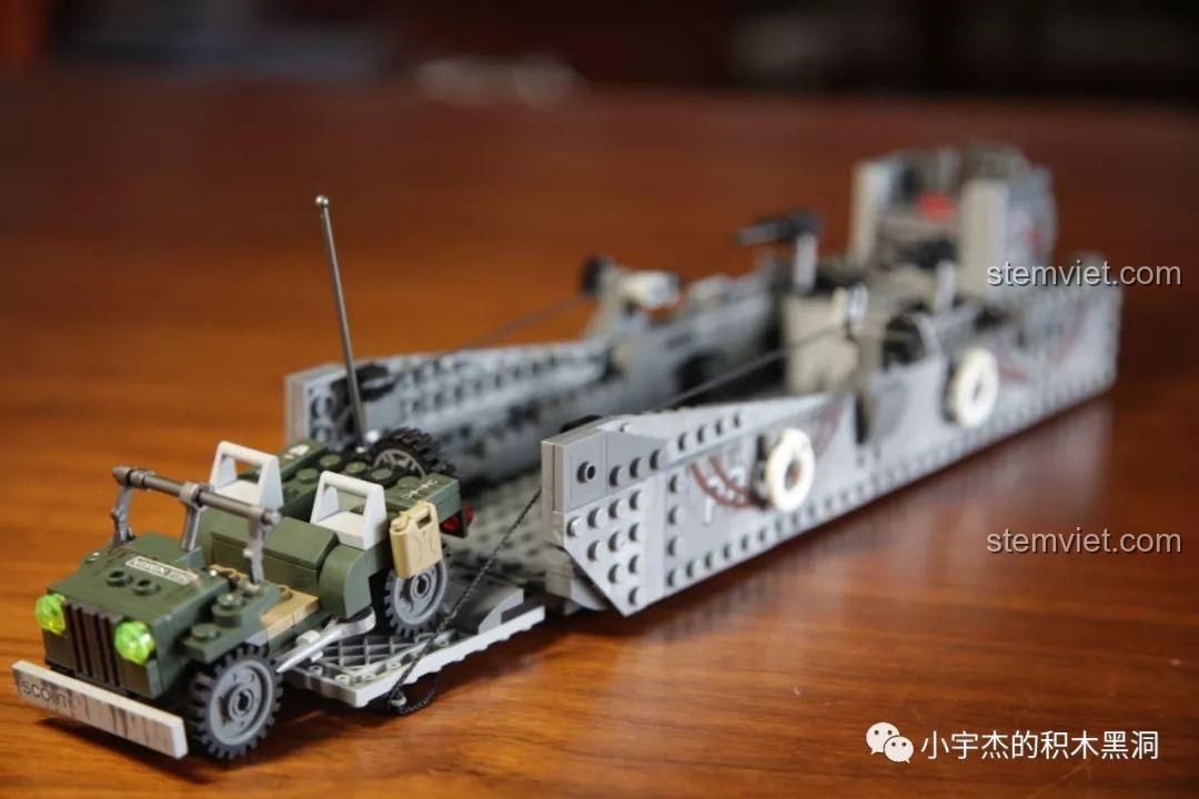 Cảnh xe Jeep đang từ từ tiến ra khỏi tàu đổ bộ qua cửa trước đang được hạ xuống.