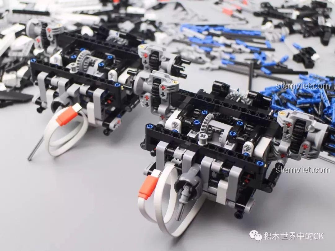 Hai cụm khung gầm và hệ thống treo của bộ lắp ráp Xe tải quái vật cho bé trên 14 tuổi, được đặt cạnh nhau để so sánh.