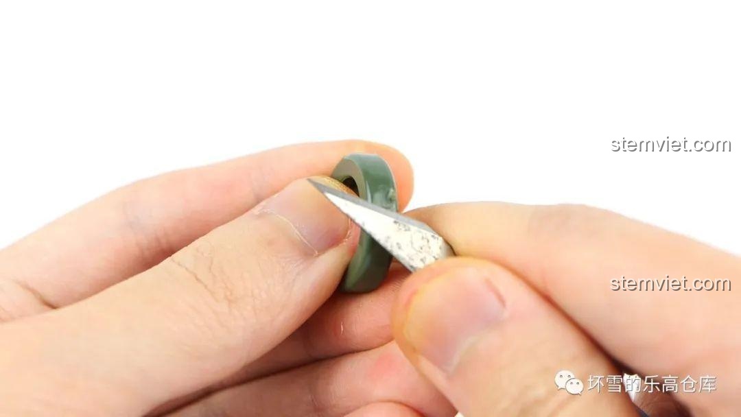 Dùng dao để cắt bỏ phần thừa trên vòng cao su của bánh xe tăng KV-1 QUANGUAN, đảm bảo độ trơn tru.