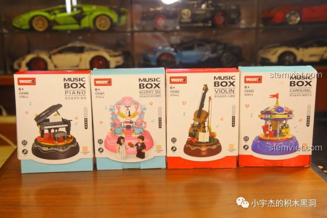 Bốn hộp sản phẩm của bộ sưu tập hộp nhạc WOMA C0360-C0363, gồm Piano, Marry Me, Violin và Carousel, xếp cạnh nhau trên bàn gỗ.
