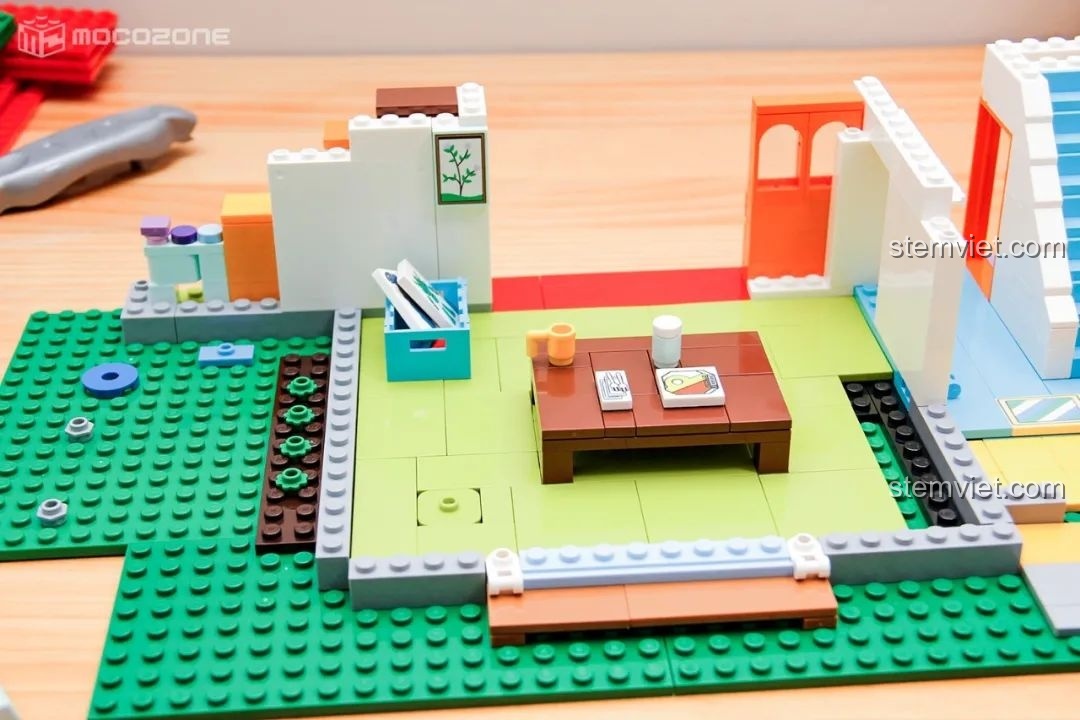 Phòng khách của gia đình Shin-chan đang được lắp ráp, với bàn trà, tranh treo tường và các vật dụng trang trí nhỏ.