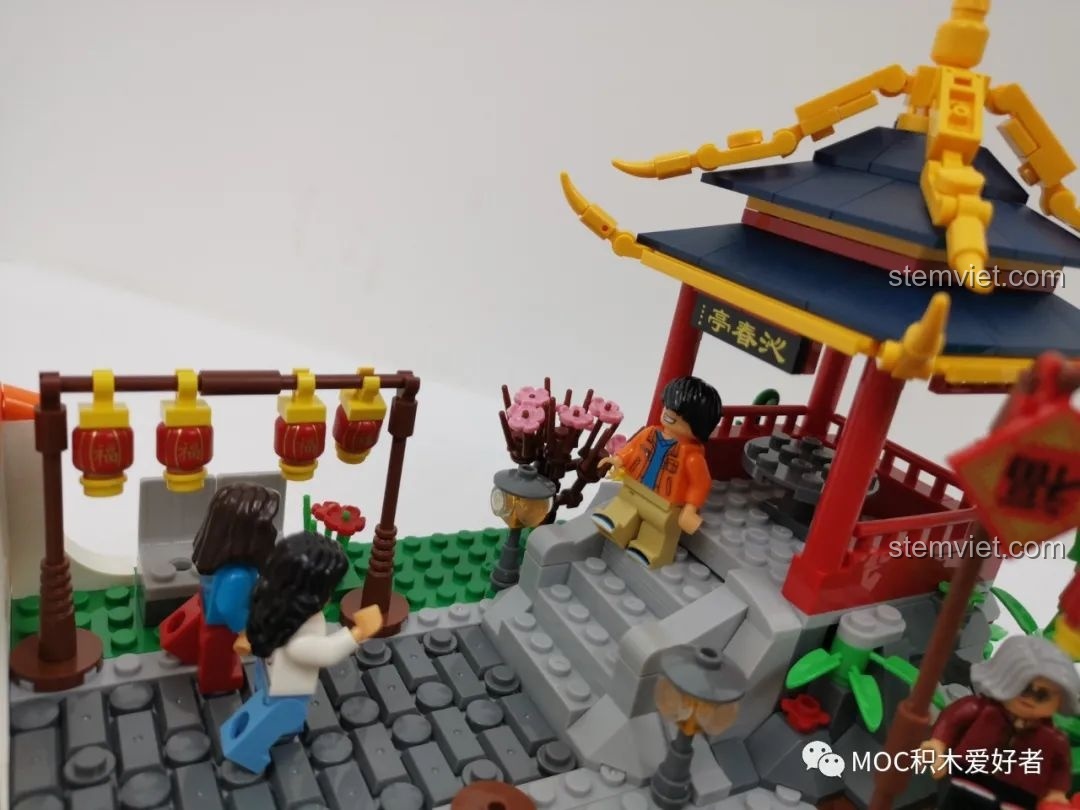 Hai minifigure ông bà đang thưởng trà trong bộ xếp hình WOMA C9123, một cảnh tượng ấm cúng.