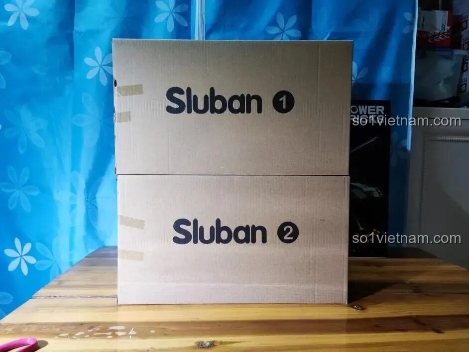 Hai hộp carton không in hình bên trong bộ lắp ráp Sluban, chứa các túi chi tiết được sắp xếp gọn gàng.