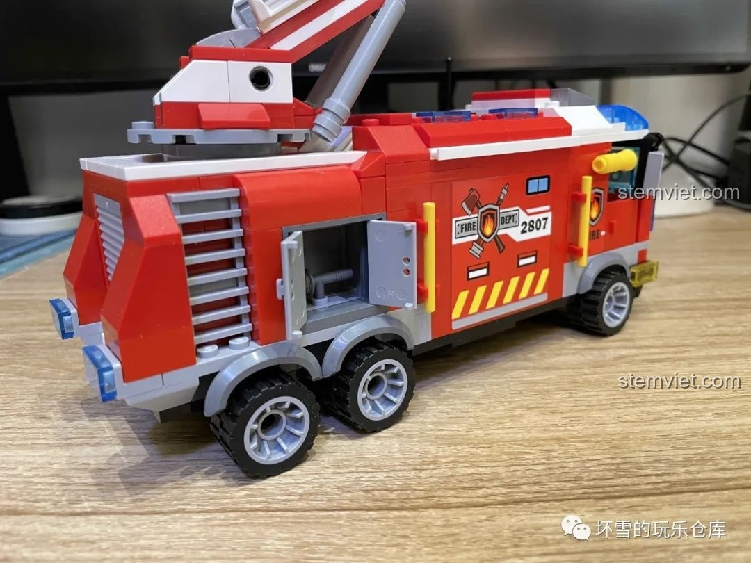 Góc nhìn từ phía sau xe cứu hỏa QMAN 2807, cho thấy các khoang chứa đồ và chi tiết bên hông xe.