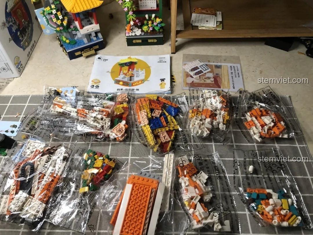 Các túi mảnh ghép của bộ Wekki 506004 Cảnh Thu được sắp xếp gọn gàng trên bàn, sẵn sàng cho việc lắp ráp.