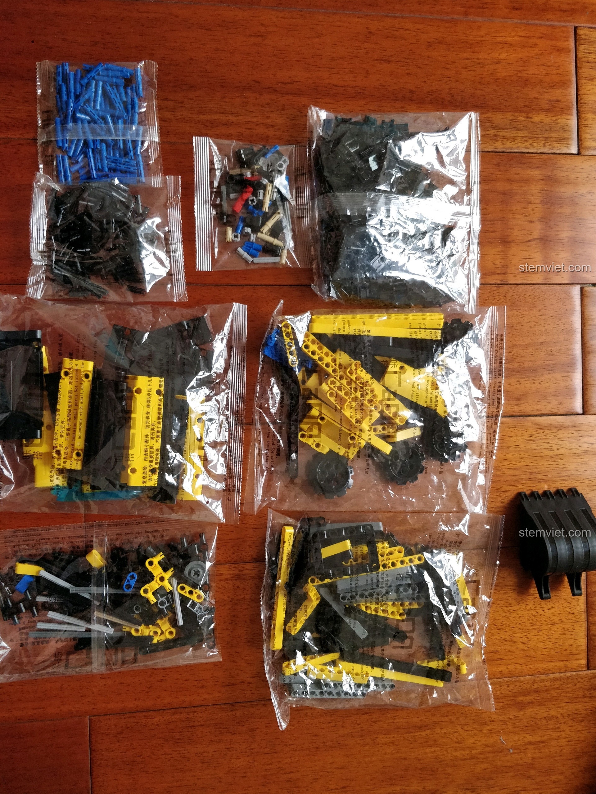 Các túi chi tiết được đánh số và chiếc gầu xúc của đồ chơi lắp ghép Xe đào đất bánh xích C51057 xịn giá rẻ.