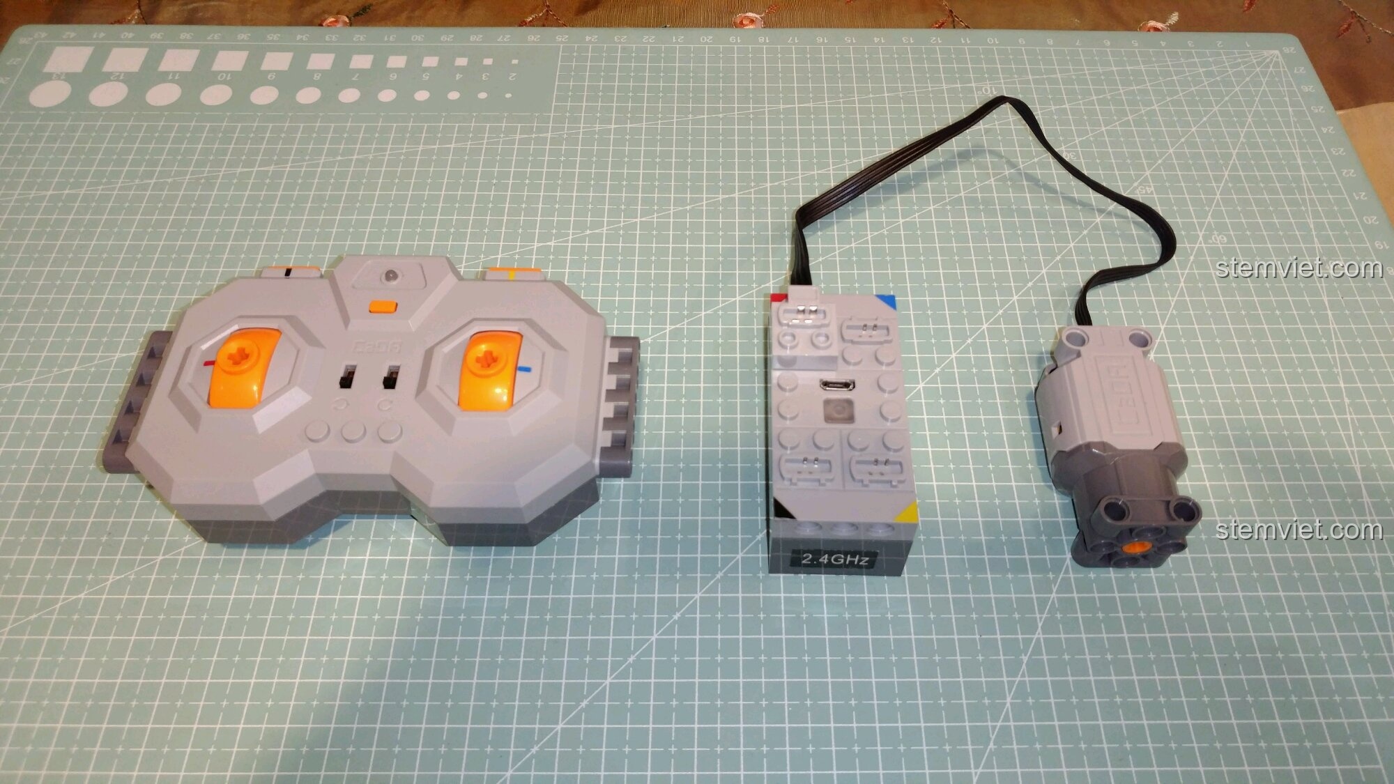 Bộ ba linh kiện điện tử của CaDA C51028: tay cầm điều khiển, hộp pin và động cơ L-motor.