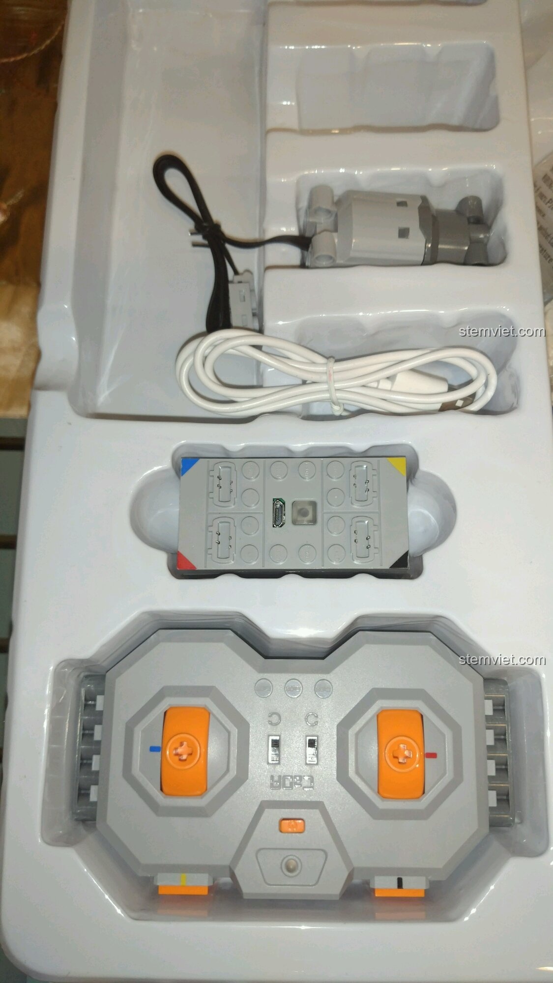 Cận cảnh khay đựng bộ phận điện tử của CaDA C51028: điều khiển, hộp pin, động cơ và dây sạc.