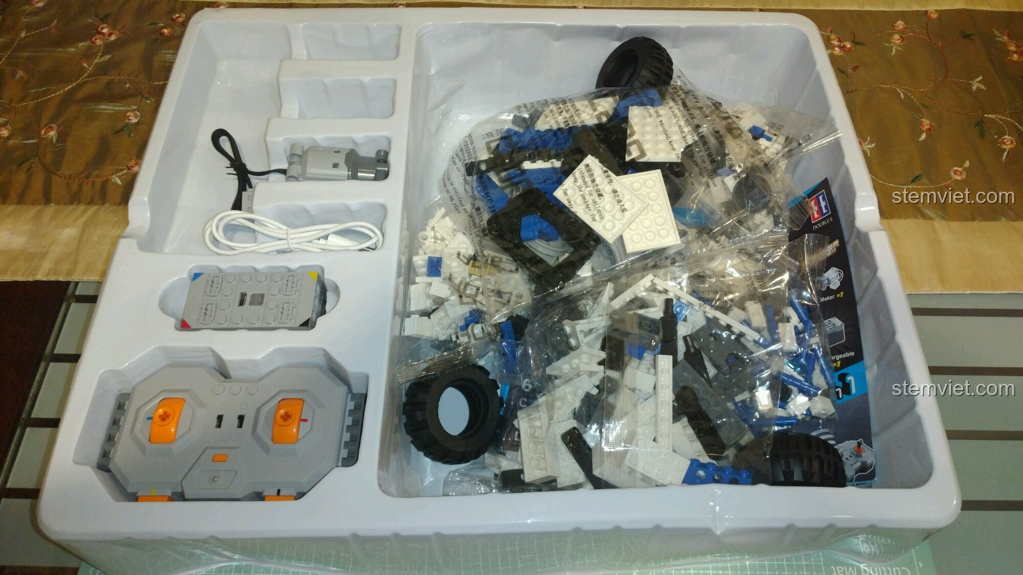 Bên trong hộp CaDA C51028 Robot DADA với khay nhựa đựng các túi chi tiết và bộ phận điện tử.