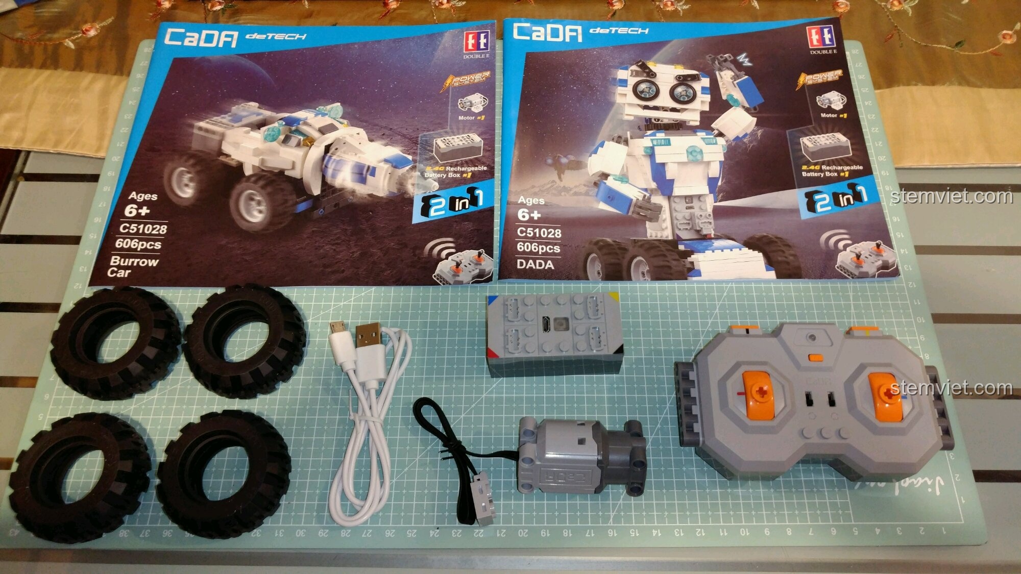 Toàn bộ các thành phần trong hộp CaDA C51028 Robot DADA, bao gồm sách hướng dẫn, bánh xe, và bộ điện.
