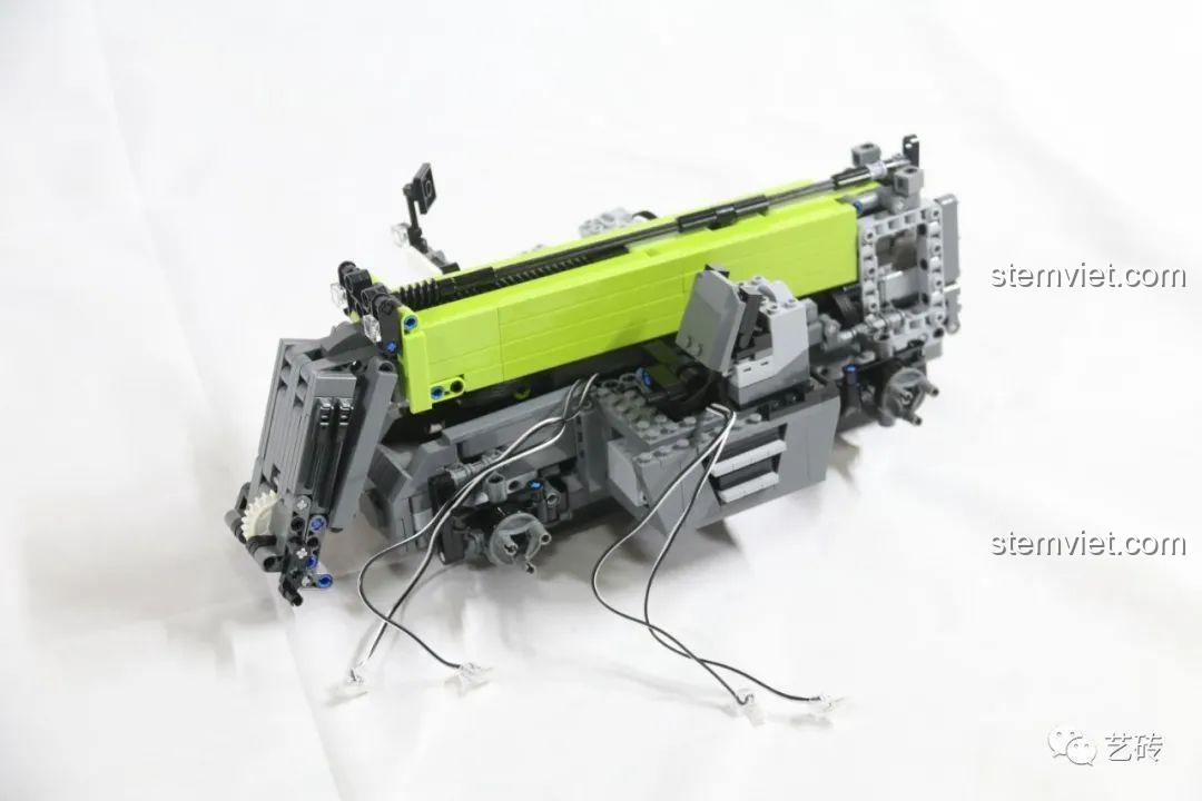 Phần khung và cánh tay nâng của xe CaDA C61051 trước khi lắp vỏ ngoài, để lộ hệ thống dây điện phức tạp.
