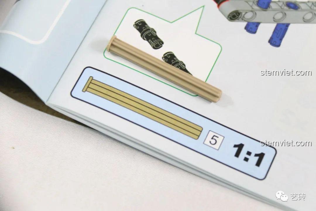 Sách hướng dẫn lắp ráp của bộ CaDA C61051, có hình ảnh so sánh tỉ lệ 1:1 của một chi tiết trục technic màu be.