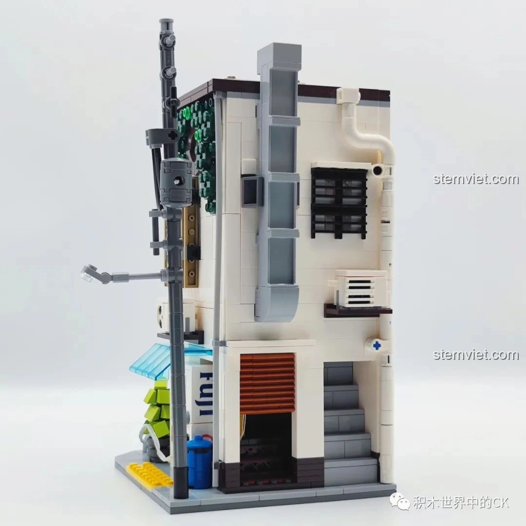 Góc sau bên trái của mô hình đồ chơi CaDA C66006 Nhà Bánh Bao Nhật Bản, với các chi tiết ống thoát nước và cửa cuốn.