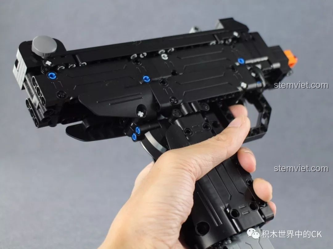 Một người đang cầm mô hình súng UZI CaDA C81008 trên tay, thể hiện kích thước và cảm giác cầm nắm thực tế.