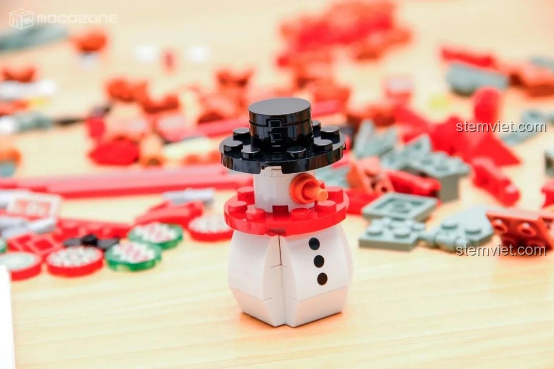 Minifigure Người tuyết của Hộp nhạc Giáng Sinh Xoay Tự Động JAKI JK1365, đội mũ đen và khăn quàng đỏ, thiết kế đơn giản nhưng dễ thương.