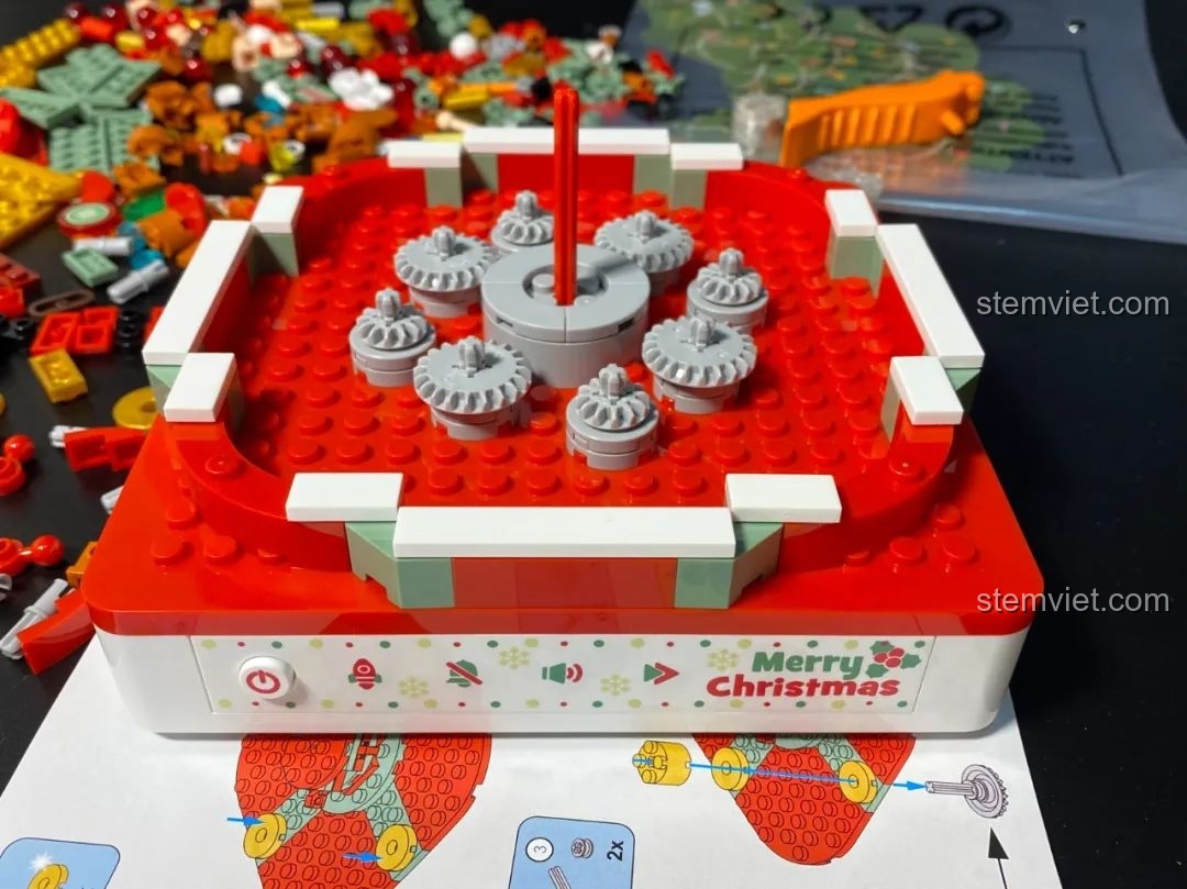 Cơ chế truyền động của đế nhạc Hộp nhạc Giáng Sinh Xoay Tự Động JAKI JK1365, với các bánh răng lớn và nhỏ. Đồ chơi lắp ráp Giáng Sinh có nhạc.