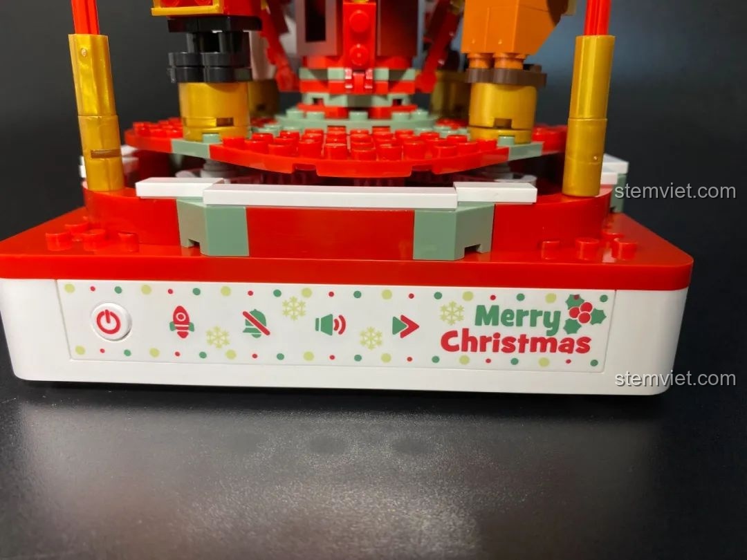 Cận cảnh trục xoay bên trong Hộp nhạc Giáng Sinh Xoay Tự Động JAKI JK1365 với dải trang trí màu sắc. Đồ chơi lắp ráp Giáng Sinh có nhạc.