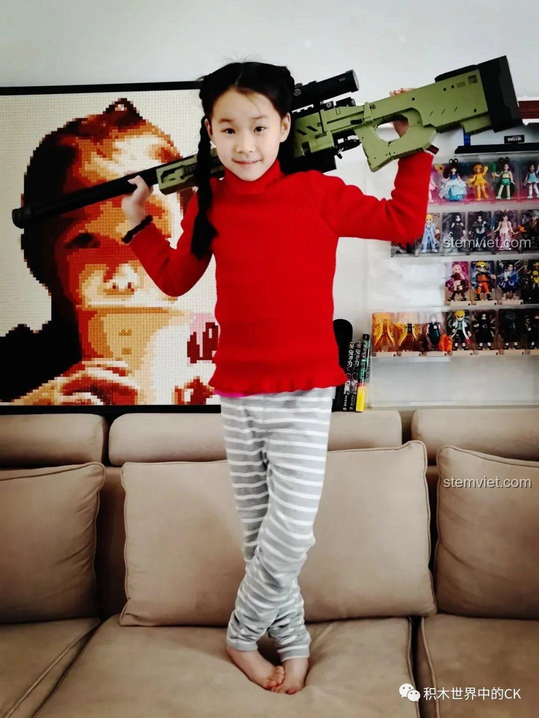 Bé gái tự tin tạo dáng với mô hình súng bắn tỉa AWP JIESTAR 58022, thể hiện sự tự hào và niềm vui.