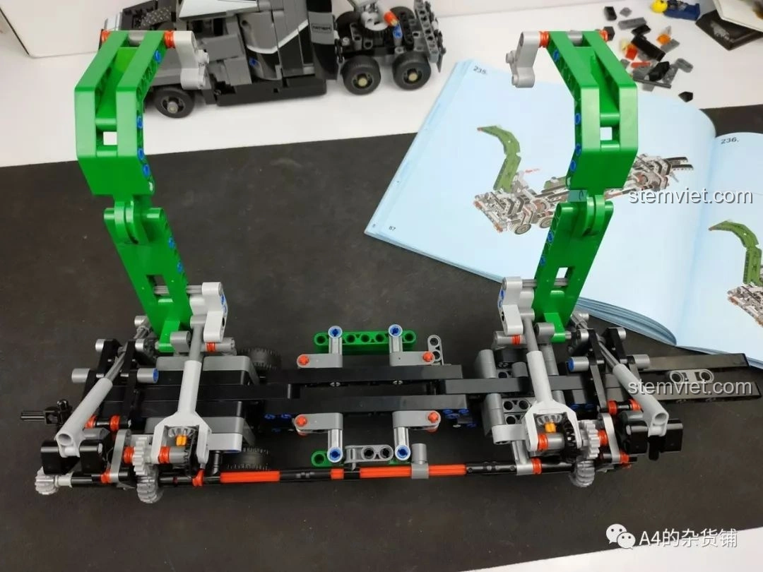 Phần cần cẩu của xe tải đang được lắp ráp, với hai cánh tay màu xanh lá cây và cơ chế nâng hạ, của bộ lắp ráp Xe Tải Container Cơ Khí SEMBO 703940.