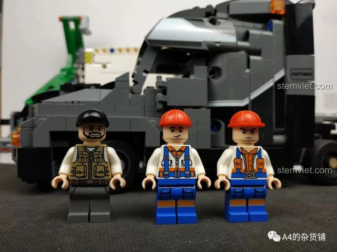 Ba nhân vật minifigure công nhân đứng trước xe tải container đã hoàn thiện, của bộ lắp ráp Xe Tải Container Cơ Khí SEMBO 703940.