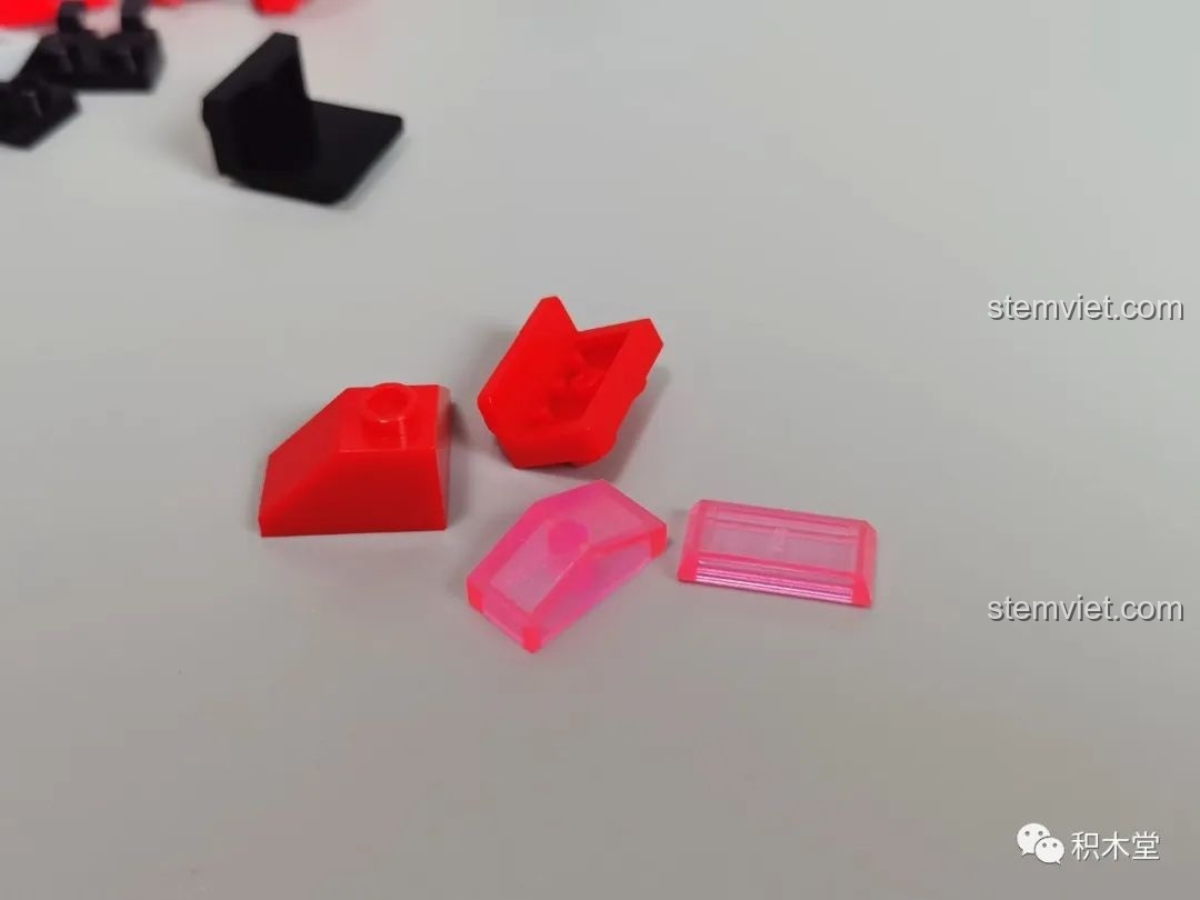 Cận cảnh các mảnh ghép màu đỏ và mảnh trong suốt màu hồng của bộ Sluban M38-B1152 Robot Cơ Giáp Quang Kích Athena, cho thấy chất lượng màu sắc.