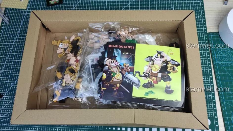Bên trong hộp bộ lắp ghép Sluban M38-B1009 Mô hình Trư Bát Giới, các túi linh kiện và sách hướng dẫn được sắp xếp gọn gàng.