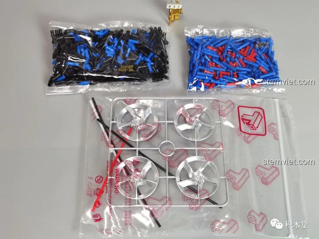 Các chốt nối màu xanh và đen, cùng với bộ vành và lốp xe cứng cáp, sẵn sàng cho việc lắp ráp mô hình Ferrari Daytona SP3 T5032.