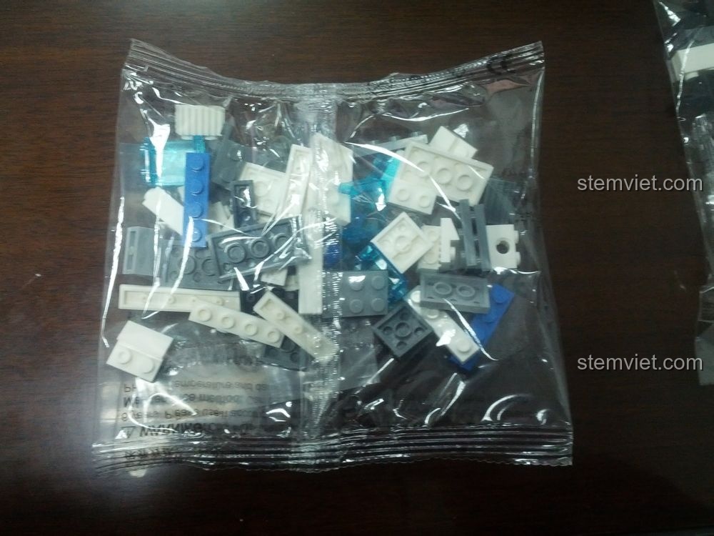 Túi mảnh ghép đầu tiên của bộ lắp ráp WANGE 51011 Xe Tuần Tra Cảnh Sát, chứa các chi tiết màu trắng và xanh trong suốt.