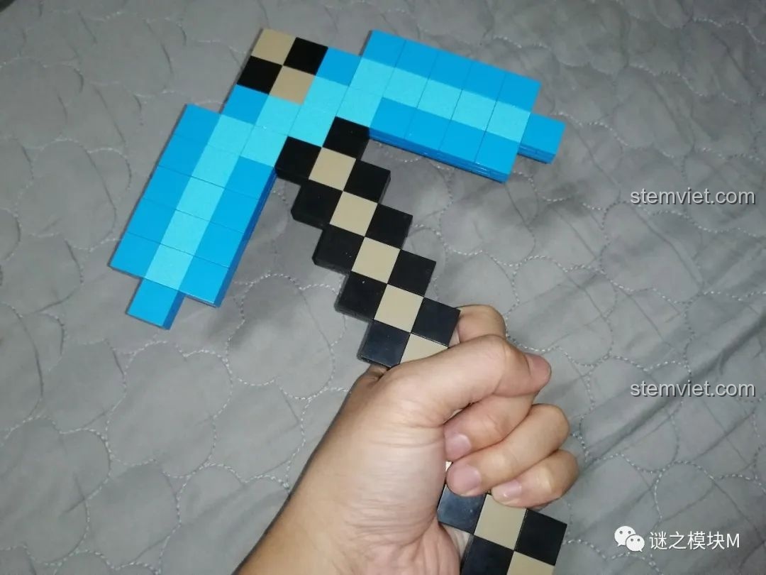 Một bàn tay đang cầm chiếc cuốc kim cương từ bộ lắp ráp RENZAIMA 733, thể hiện độ cứng cáp.