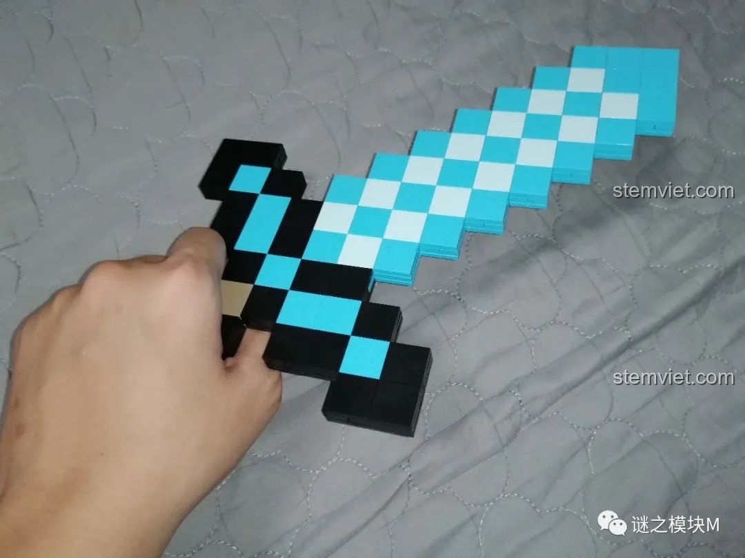 Một bàn tay đang cầm thanh kiếm kim cương từ bộ lắp ráp RENZAIMA 733, thể hiện sự chắc chắn.