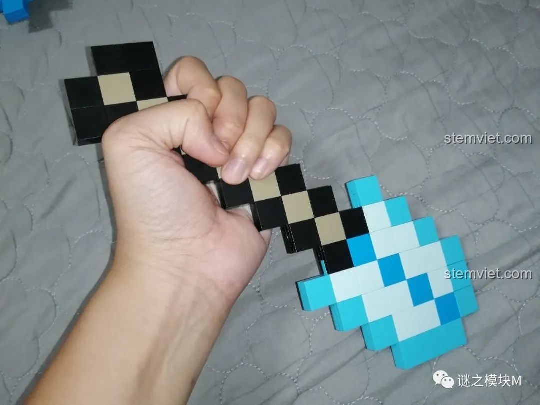 Một bàn tay đang cầm chiếc xẻng kim cương từ bộ lắp ráp RENZAIMA 733, cho thấy trải nghiệm cầm nắm.