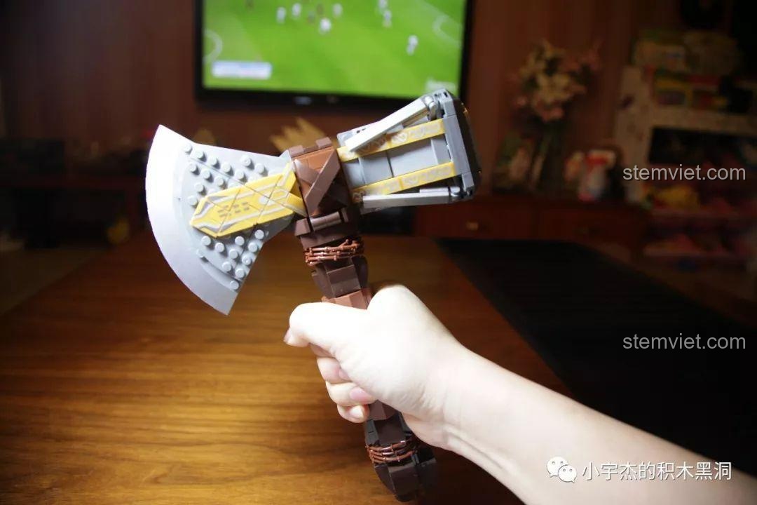 Một người đang cầm mô hình Rìu Bão Tố Stormbreaker SY1399 trên tay, thể hiện kích thước thực tế của sản phẩm.