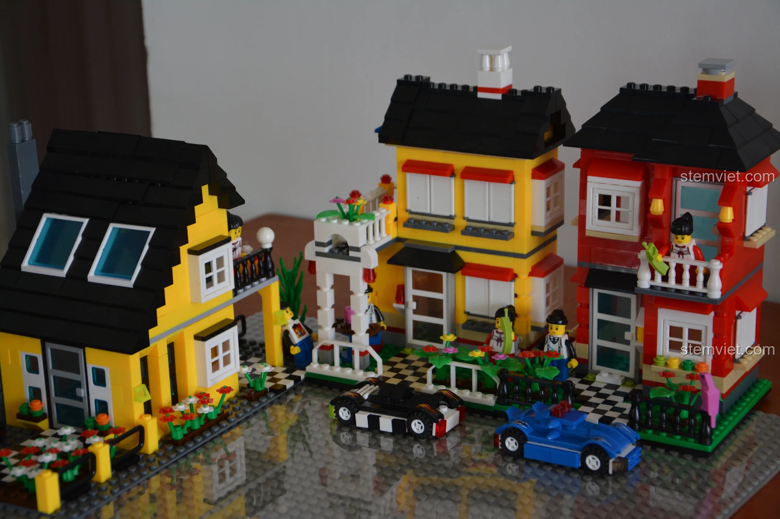 Cận cảnh Biệt Thự Vàng CityInn và hai ngôi nhà phố màu đỏ, vàng, thể hiện sự đa dạng màu sắc của thị trấn.