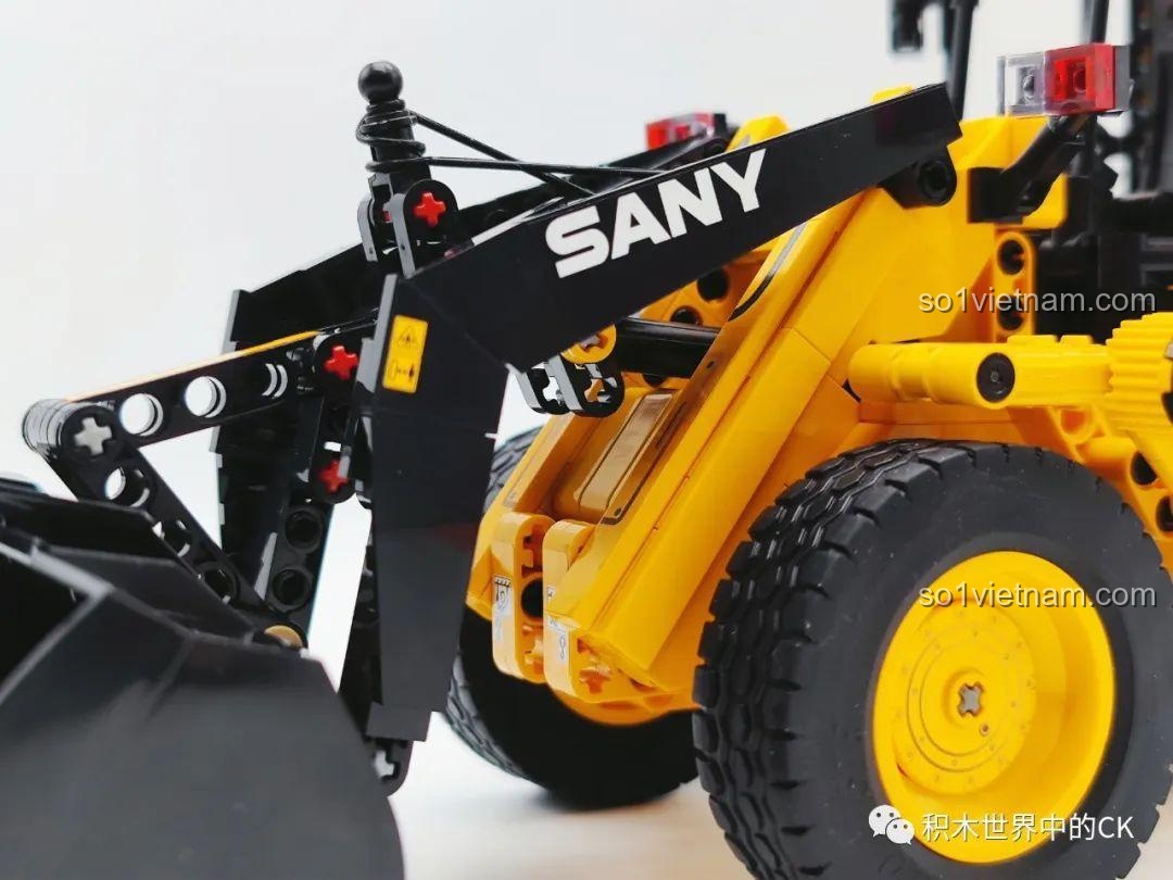 Ảnh chụp cận cảnh hệ thống cánh tay nâng của xe xúc lật Sembo 712016, với logo SANY và các khớp nối Technic.