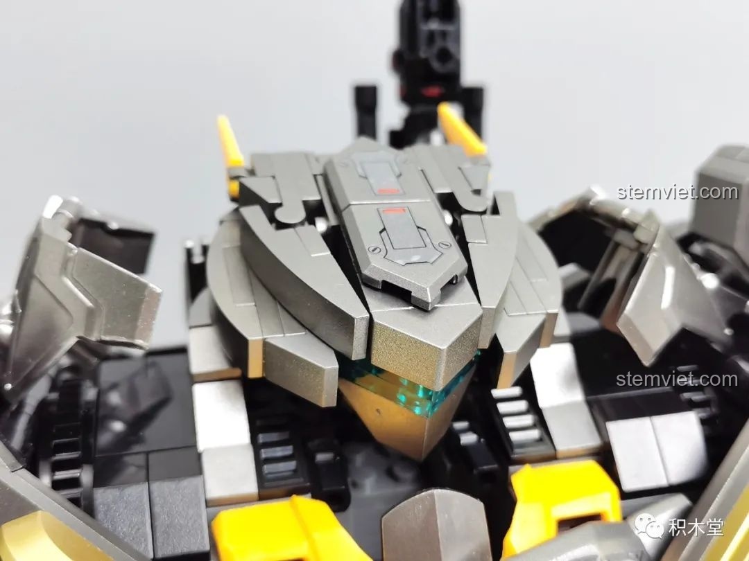 Cận cảnh chi tiết phần đầu của Robot Batmech Hạng Nặng với thiết kế góc cạnh và mắt màu xanh.