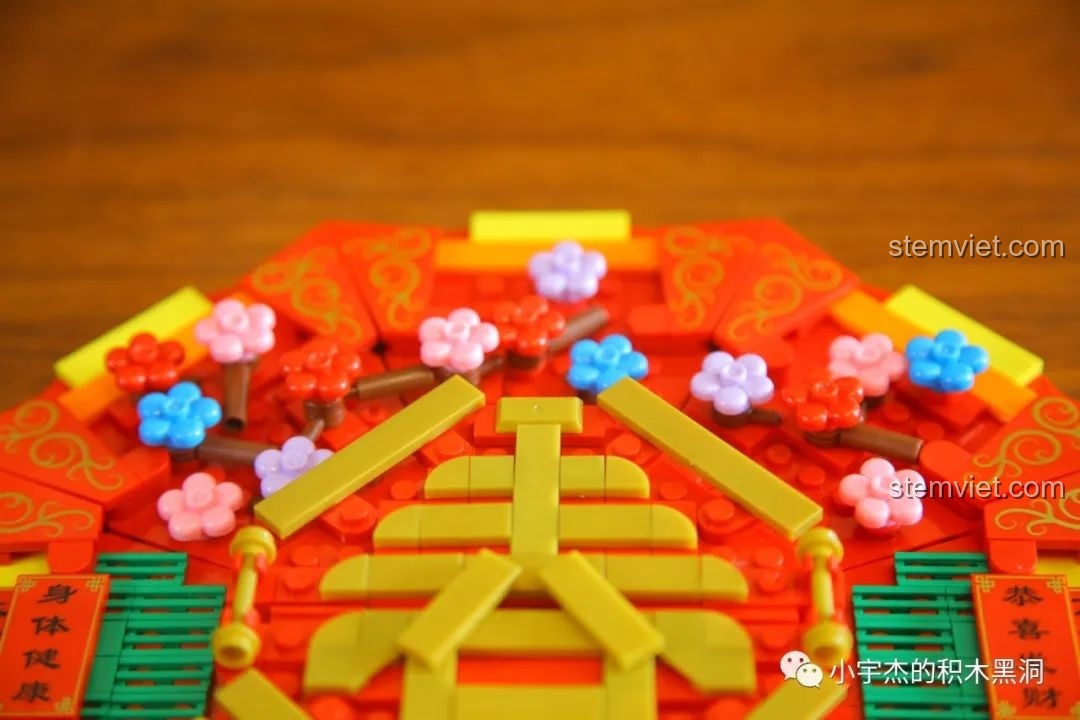 Cận cảnh chi tiết hoa mai, hoa đào nhiều màu sắc trang trí trên nắp hộp WOMA C.9122, mang không khí mùa xuân.