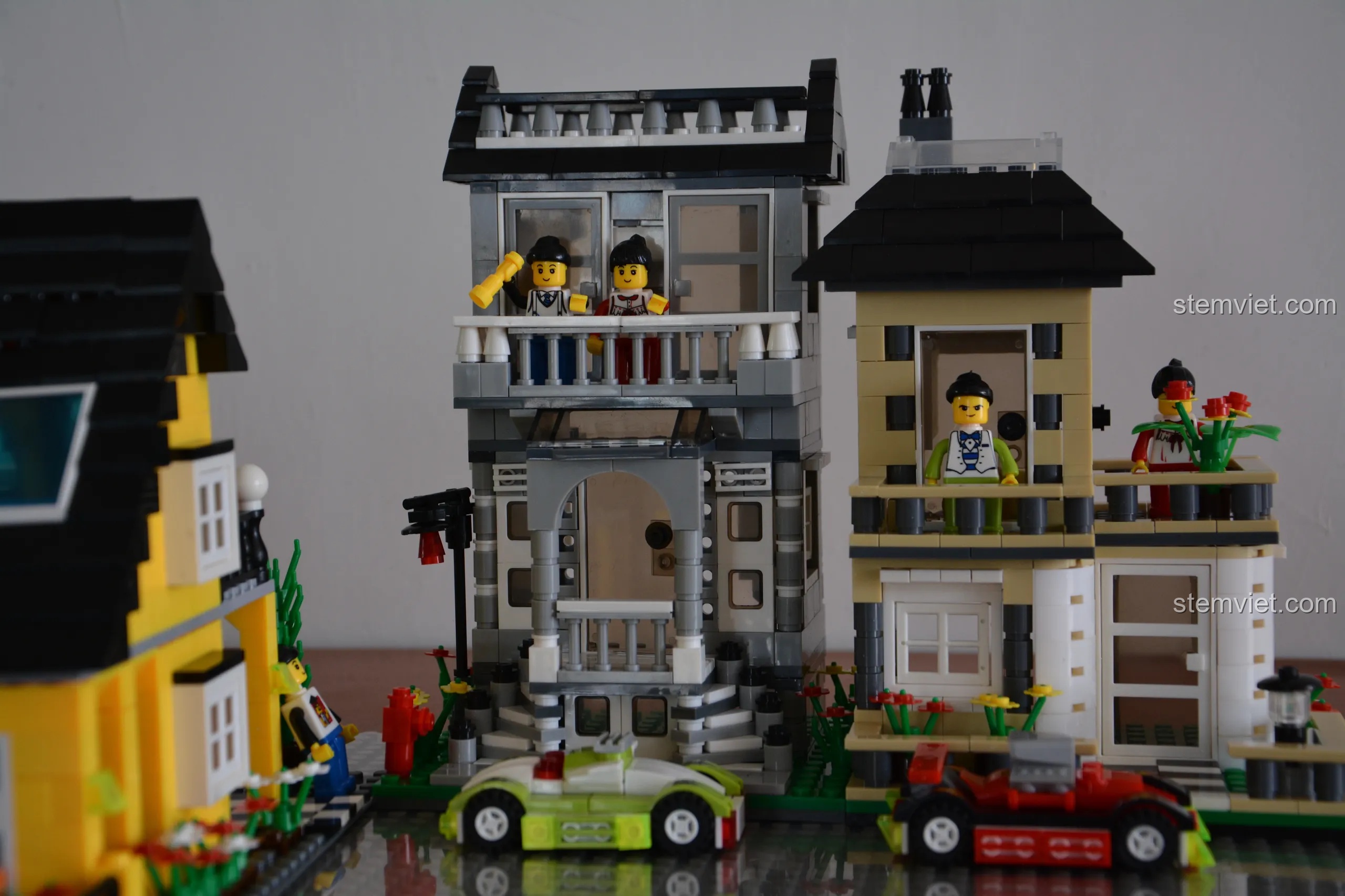 Cận cảnh hai ngôi nhà phố WANGE màu xám và nâu vàng, làm nổi bật các chi tiết kiến trúc và ban công.