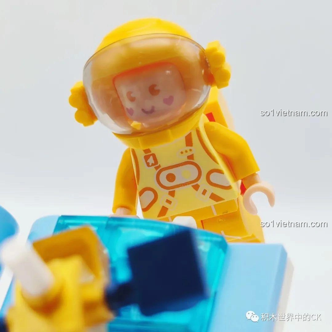Cận cảnh phi hành gia vàng của bộ đồ chơi WISE BLOCK HA390213, với biểu cảm thông minh, đôi mắt hình trái tim và bộ đồ phi hành gia màu vàng tươi.