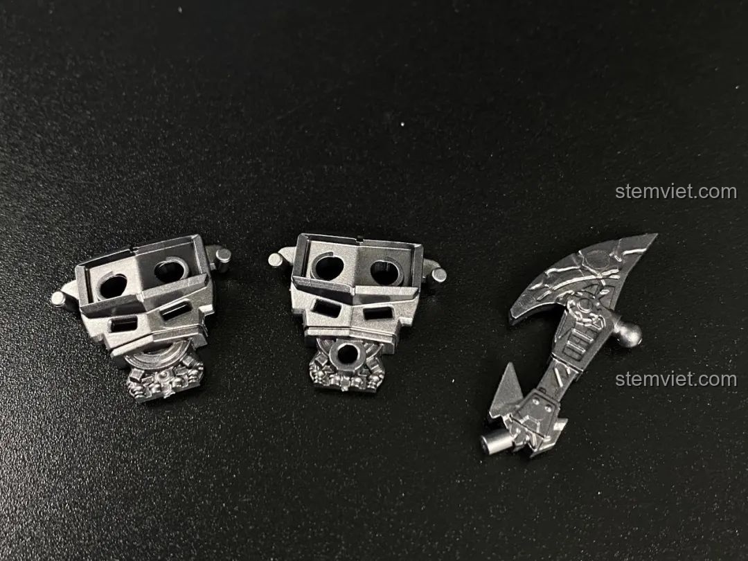 Cảnh quan chiến đấu đã lắp ráp hoàn chỉnh, với các cột đổ nát và hiệu ứng lửa, sẵn sàng cho các robot.