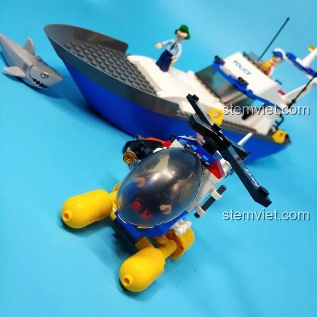 Cảnh đội cảnh sát trên tàu và trực thăng Sluban B0657 đang truy đuổi tên tội phạm, có cả cá mập và cảnh sát lặn.