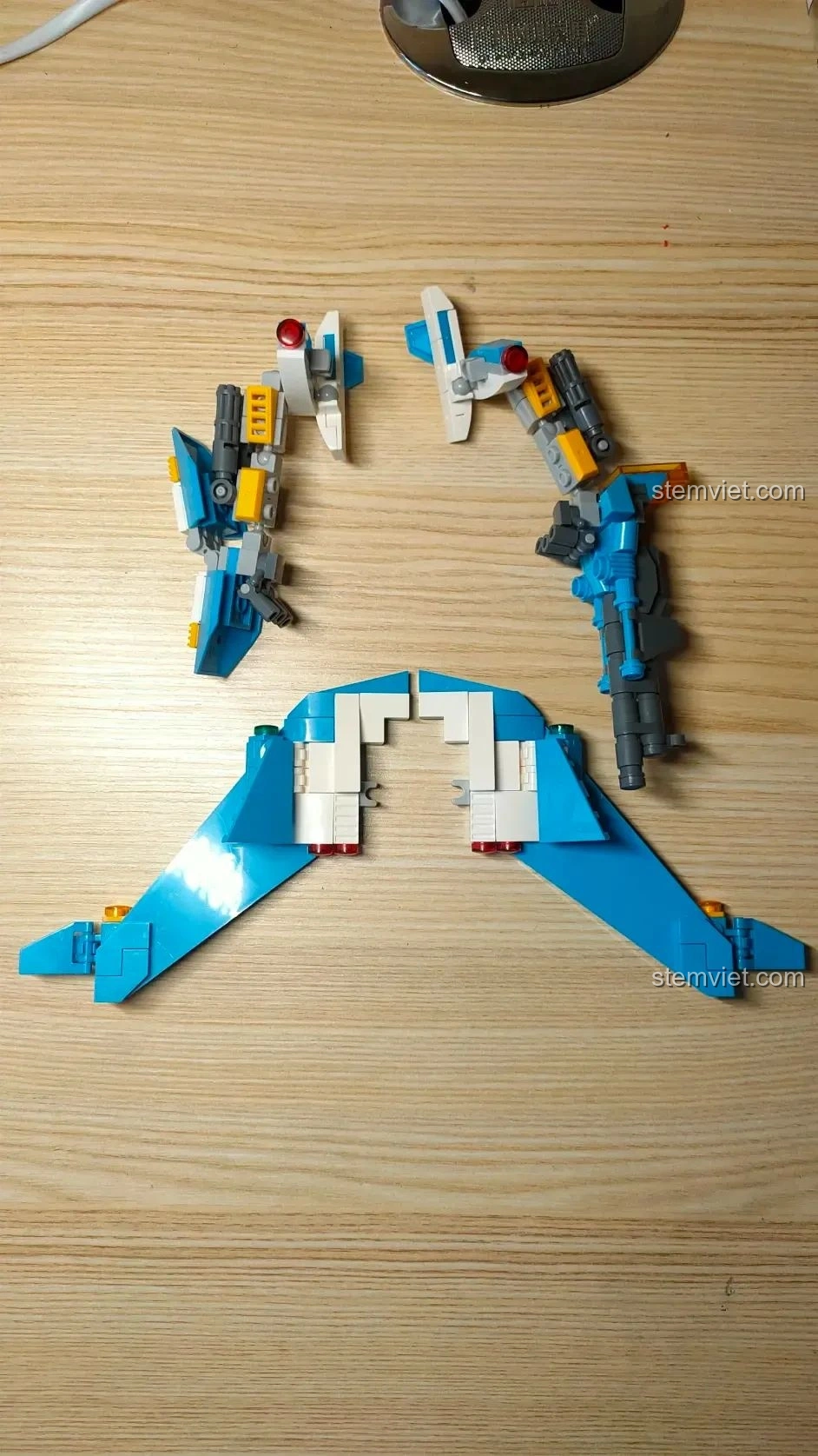 Các bộ phận cánh và tay của robot WOMA C0407 đang được lắp ráp, thể hiện sự đối xứng và chi tiết của thiết kế.