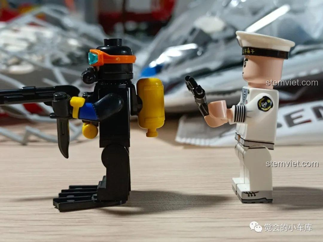 Góc nhìn bên hông của minifigure người nhái và thủy thủ, làm nổi bật các phụ kiện và chi tiết in trên trang phục của họ.