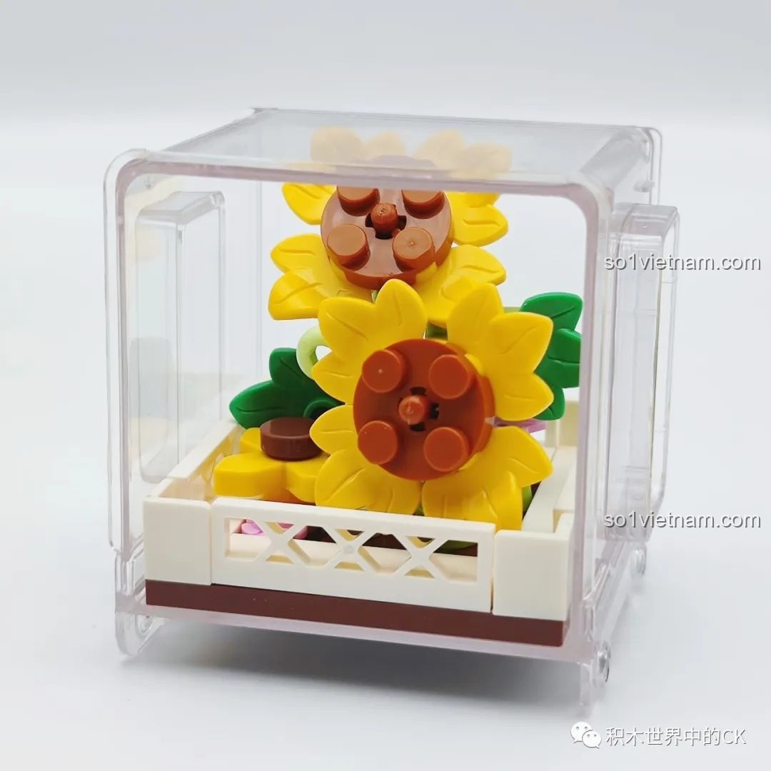 Mô hình chậu hoa hướng dương tinh nghịch đã lắp ráp xong, đặt trong hộp trưng bày trong suốt của bộ AULDEY.