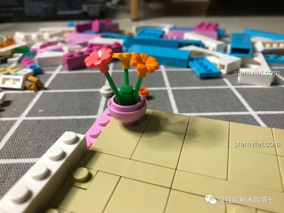 Chậu hoa màu cam được đặt trên sàn màu be của phòng ngủ trong bộ Lâu Đài Cổ Tích.