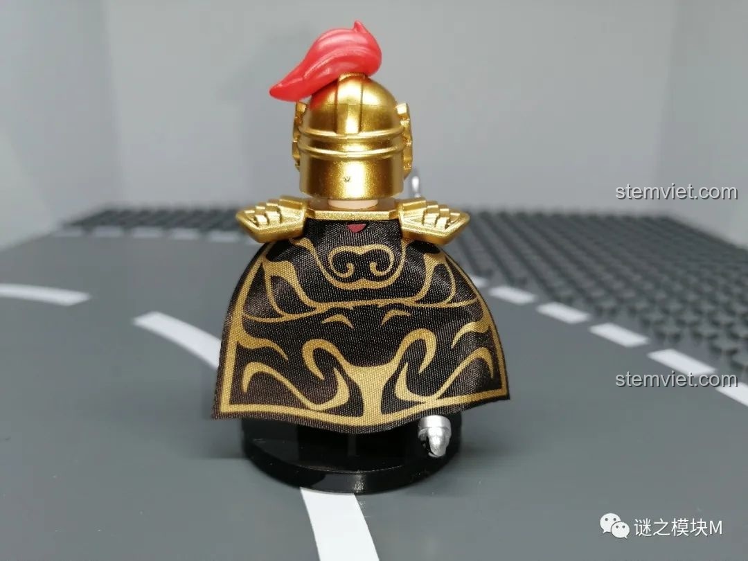 Mặt sau của minifigure Lã Mông, khoe chi tiết áo choàng đen với họa tiết vàng và mũ trụ vàng.