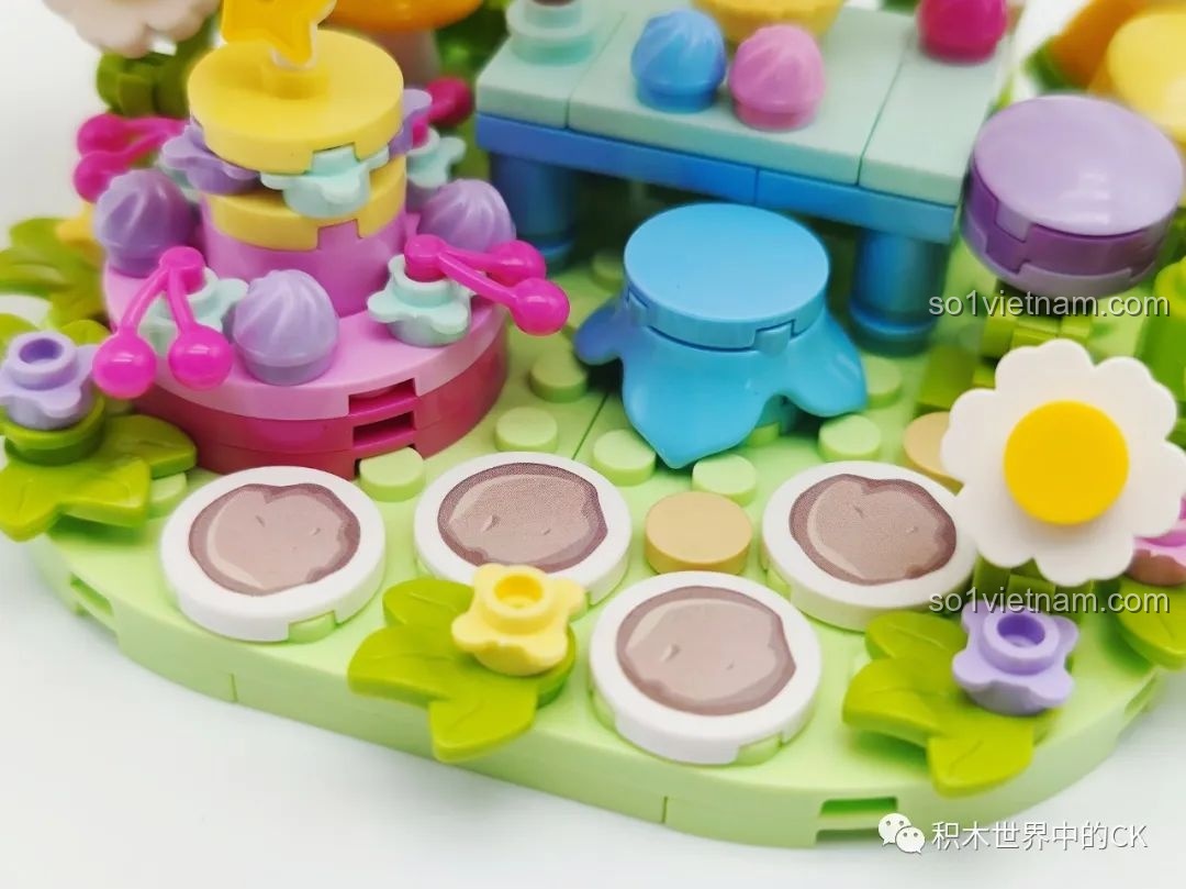 Cận cảnh chi tiết bàn tiệc với bánh kem, ghế ngồi và hoa cúc trong mô hình Khu Rừng Kẹo Bông Gòn.