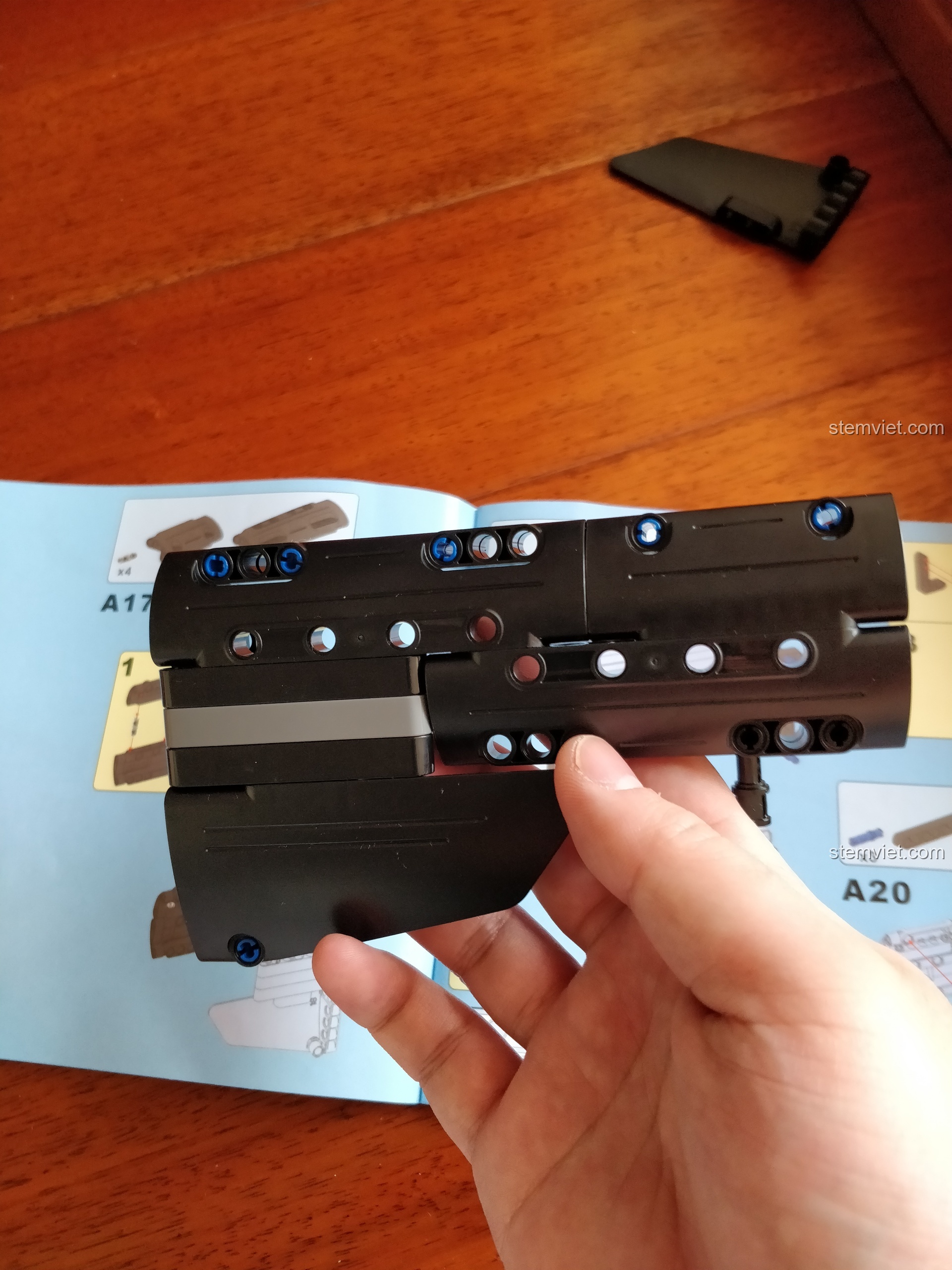 Chi tiết phần báng súng của mô hình CaDA 81005 đang được lắp ráp, cho thấy các tấm panel màu đen.