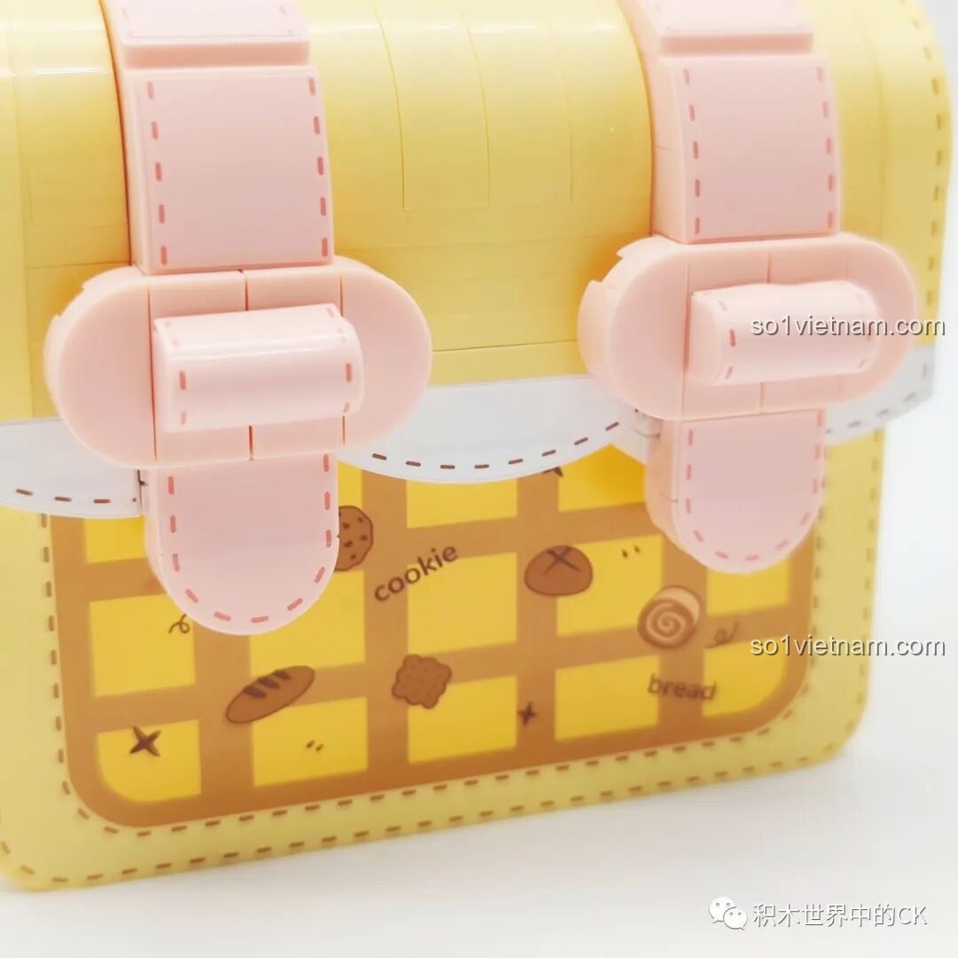 Chi tiết bên hông của túi xách Wekki 516911 với tag trang trí và vòng tròn màu hồng.